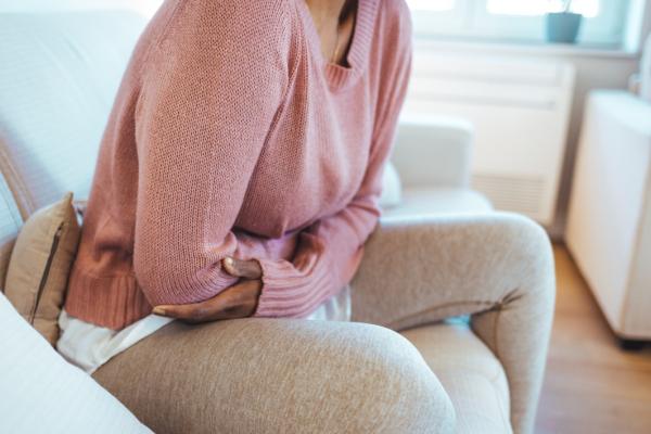 Woman on a sofa with her arms wrapped around herself