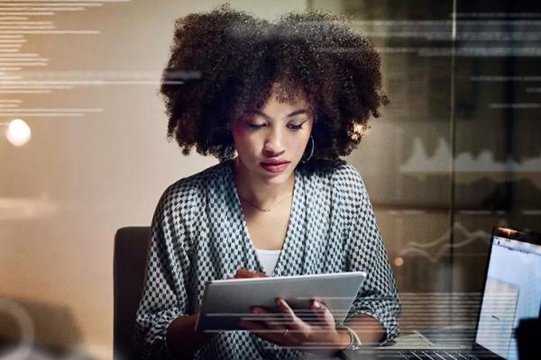 Woman looking down at a tablet screen.