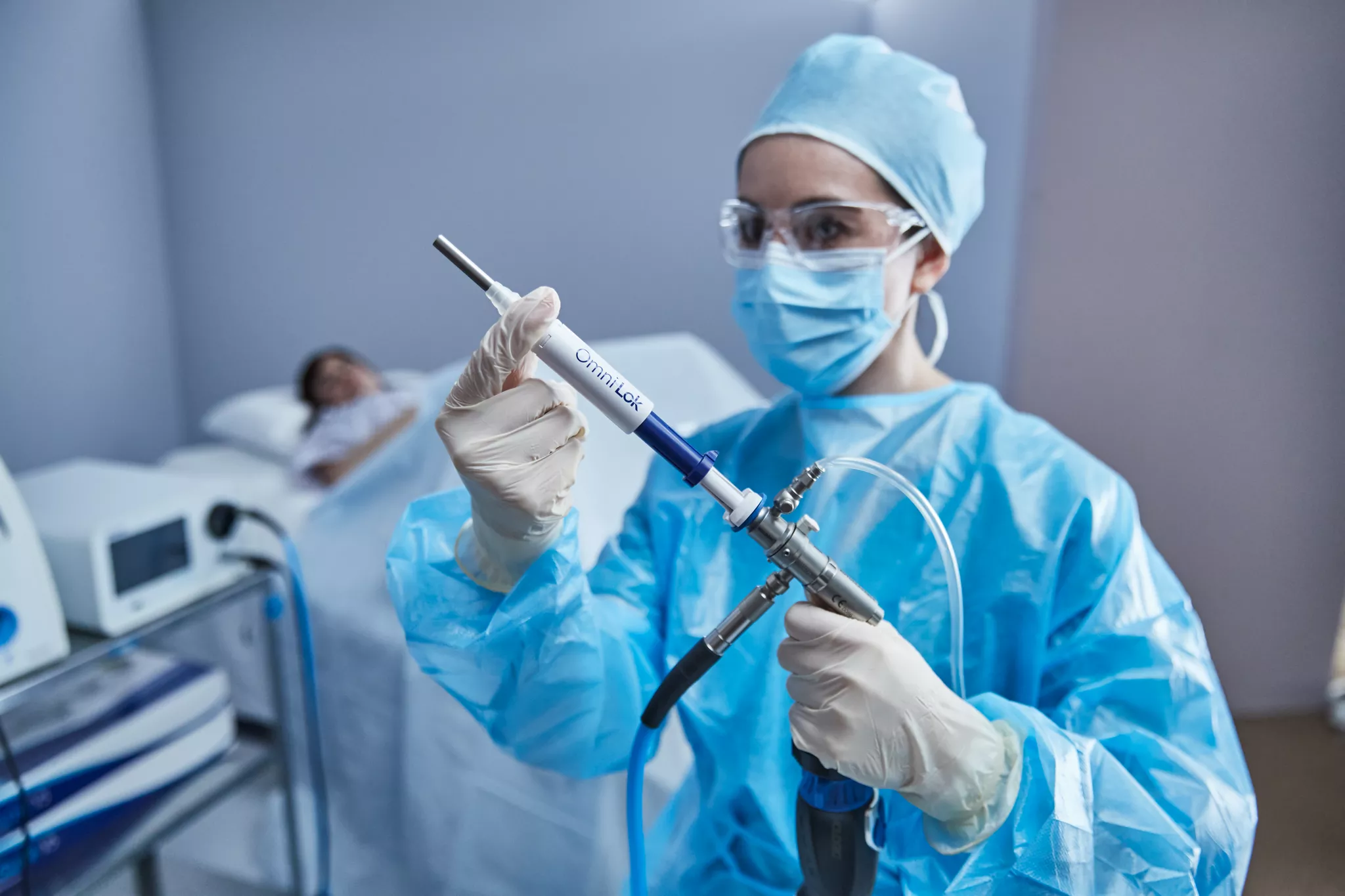 Clinician is holding a hysteroscopic device in front of a patient.