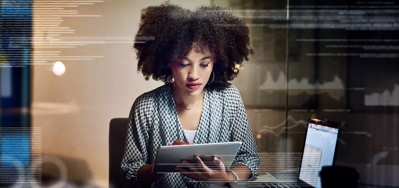 Woman looking down at a tablet screen.