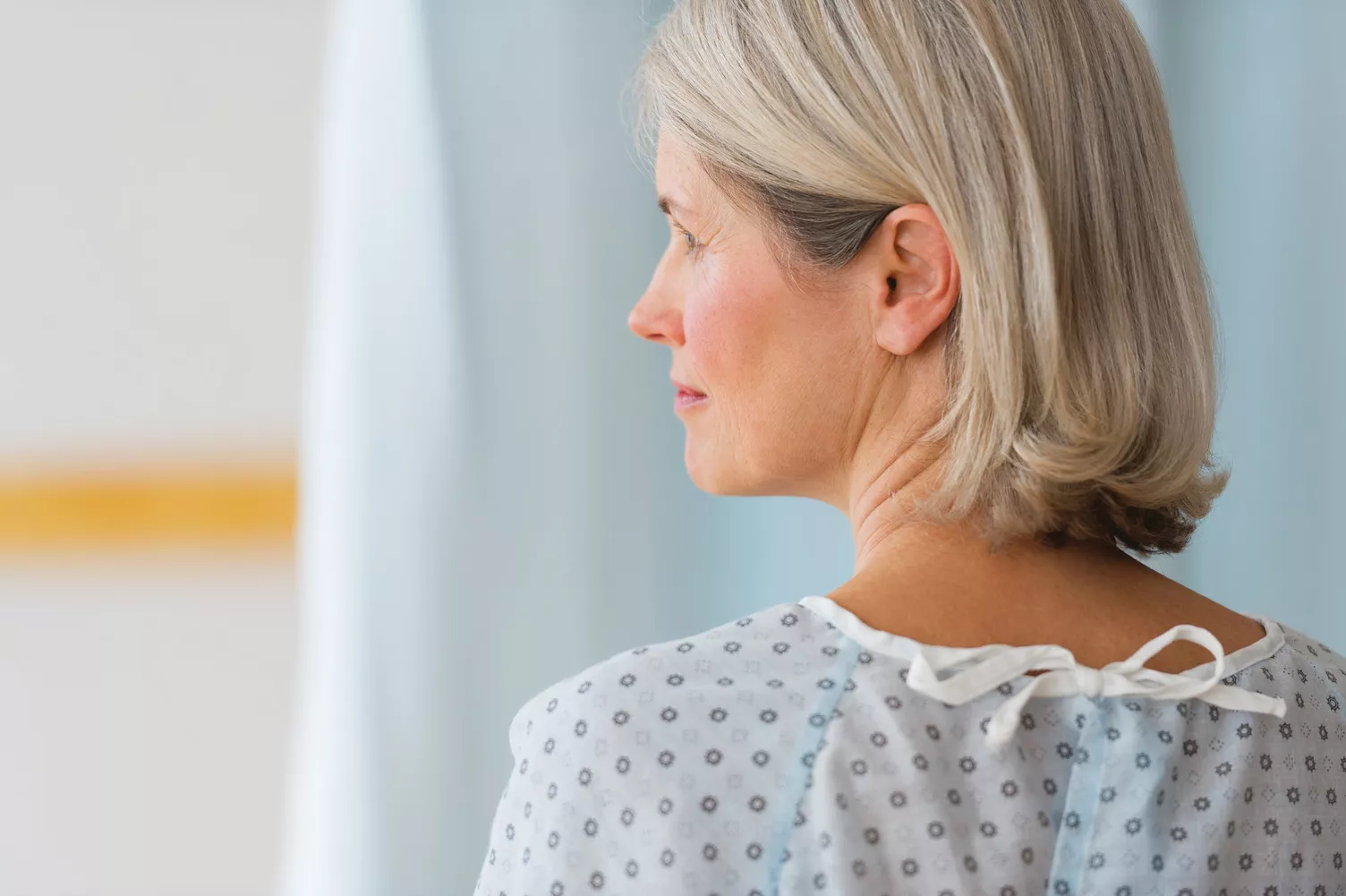 Elderly woman looking to the left wearing hospital robe