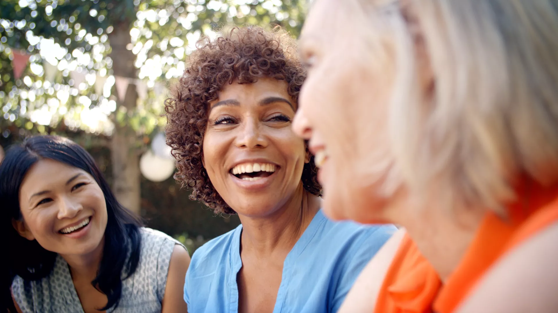 Three women talking to each other.