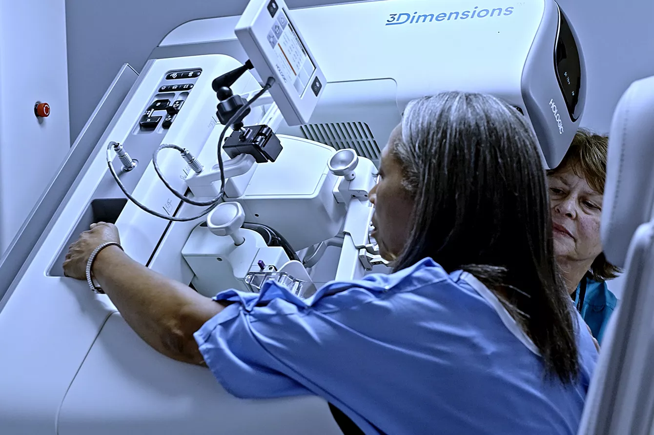 Technician using Hologic 3Dimensions mammogram system