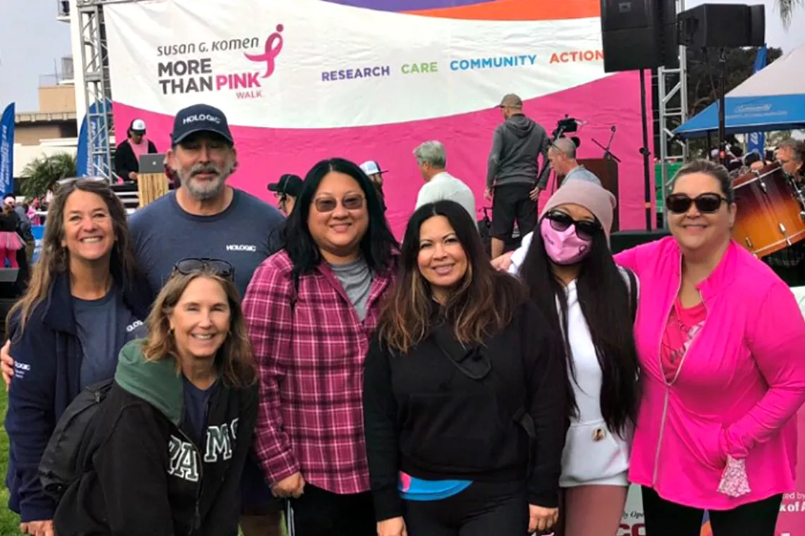 Group photo of smiling men and women at the Susan G. Komen Race for the Cure walk event