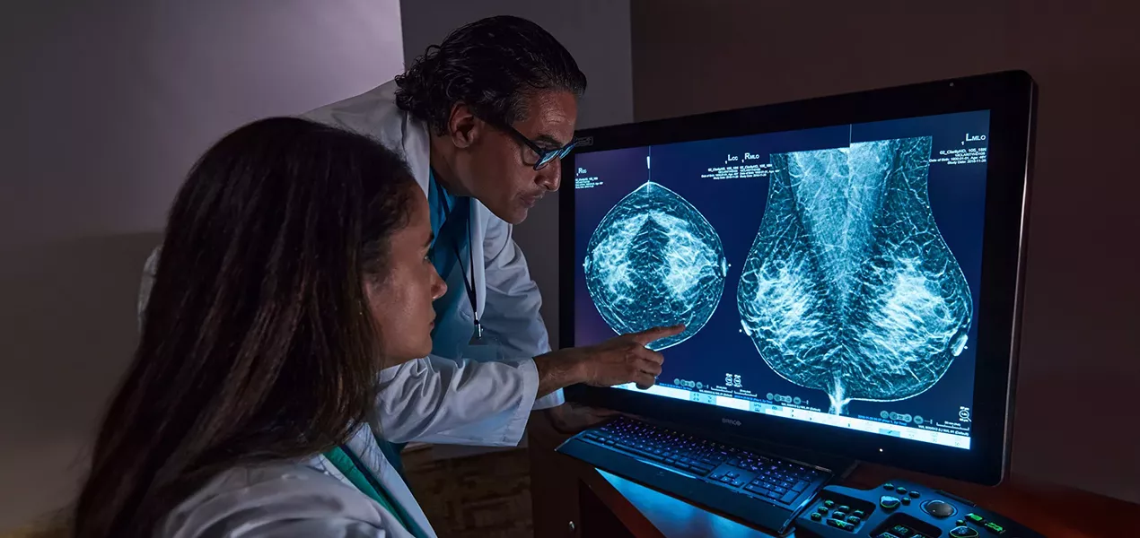 Radiographers reviewing tomosynthesis mammography on a screen