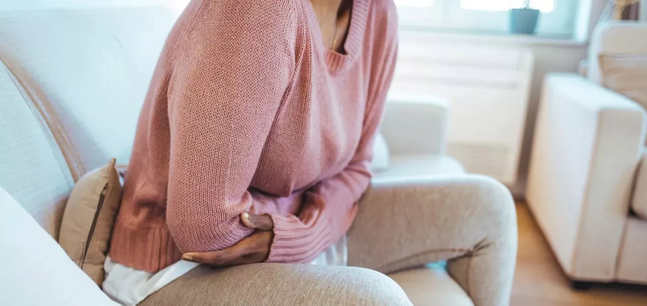 Woman on a sofa with her arms wrapped around herself